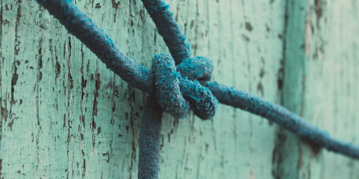 Ein blaues Seil ist zu einem gro&szlig;en Knoten gebunden.