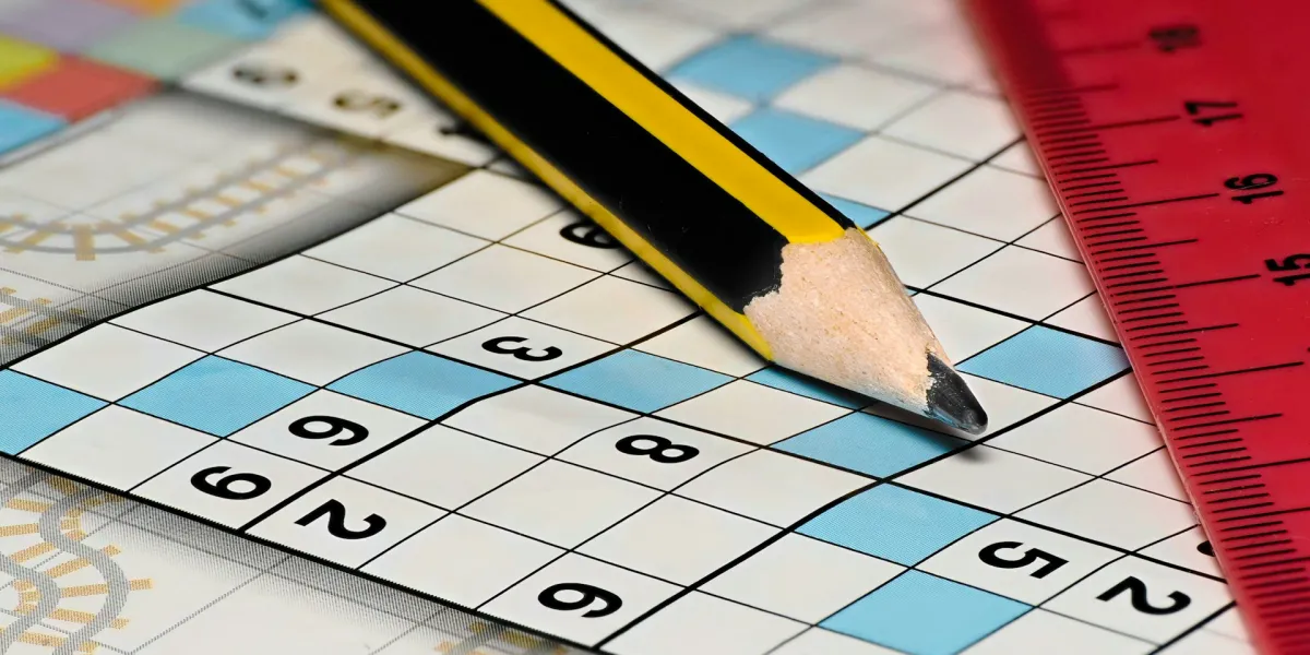 Nahaufnahme von einem Sudoku. Auf dem Papier liegt auch ein gelb-schwarzer Bleistift und ein rotes Lineal.