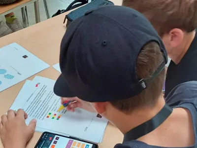 Zwei Schüler sind gerade dabei, die Rätsel vom digitalen Escape Room zu lösen.