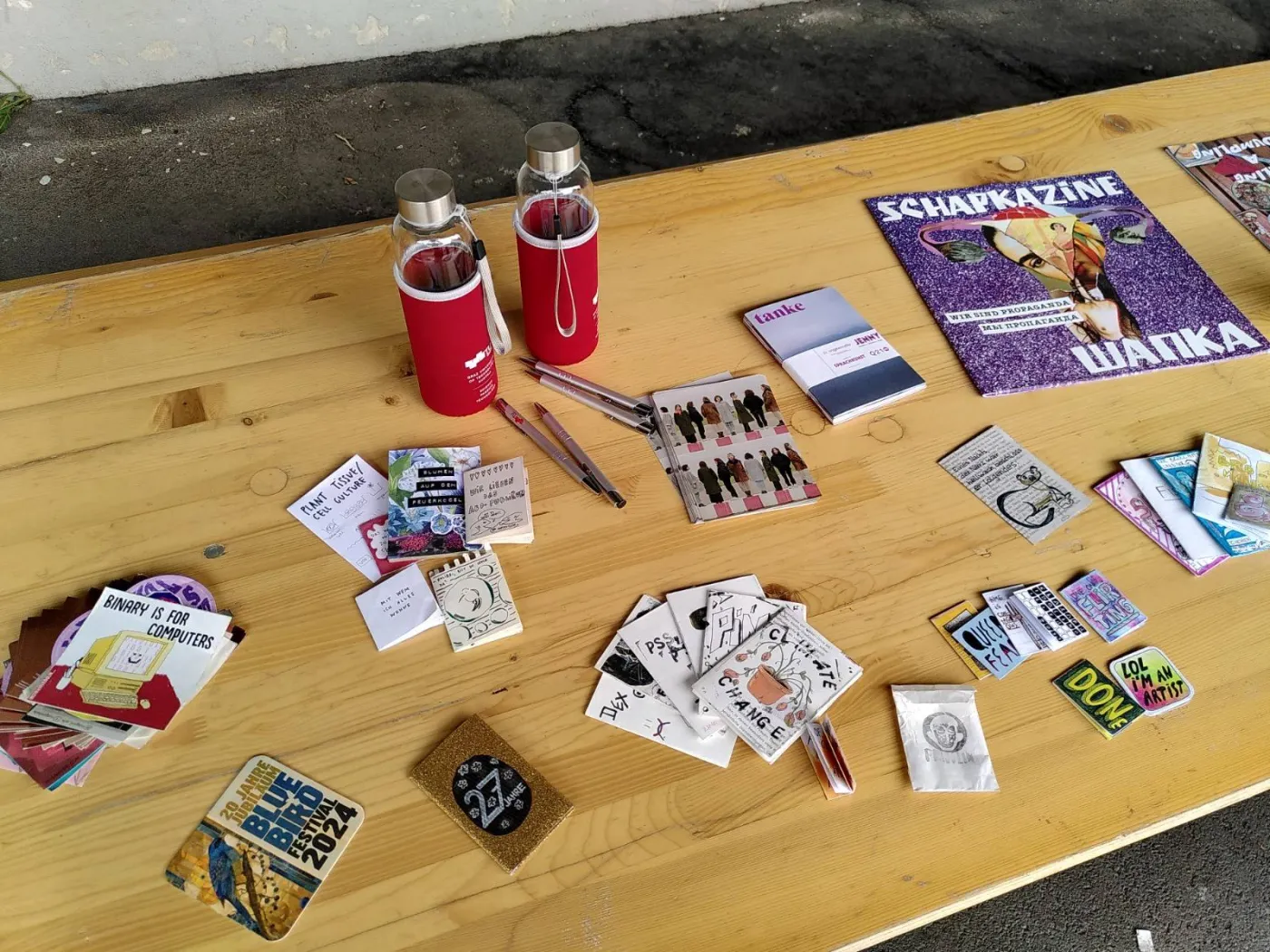 Biertisch auf dem diverse Infomaterialien (Flyer, Sticker, Merchandise) liegen.