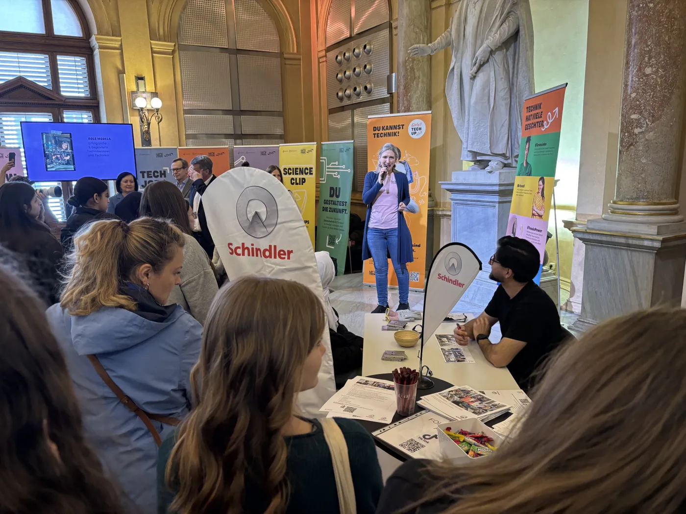 Anmoderation beim Girls-Tech-Up-Erlebnistag. Eine Frau steht auf der B&uuml;hne.