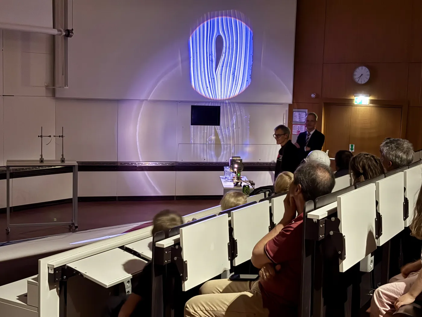 Der H&ouml;rsaal ist abgedunkelt. Mit einem Overheadprojektor werden die Luftstr&ouml;me um den Fl&uuml;gel eines Flugzeuges gezeigt.