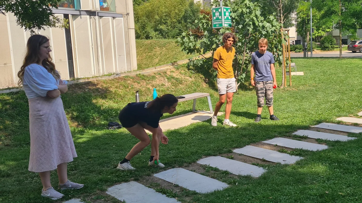 Mitten im Bocciaspiel. Eine Teilnehmer*in wirft gerade einen Ball.