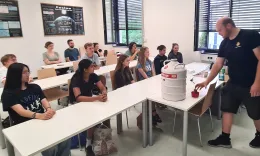 Workshopteilnehmer*innen beobachten einen Lehrer bei einem Experiment mit fl&uuml;ssigem Stickstoff.