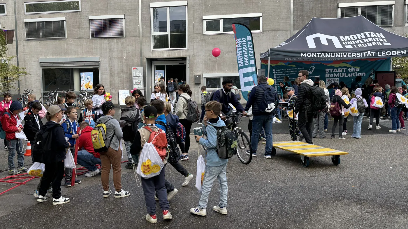 Eine Gruppe von Kindern steht vor einem Stand.