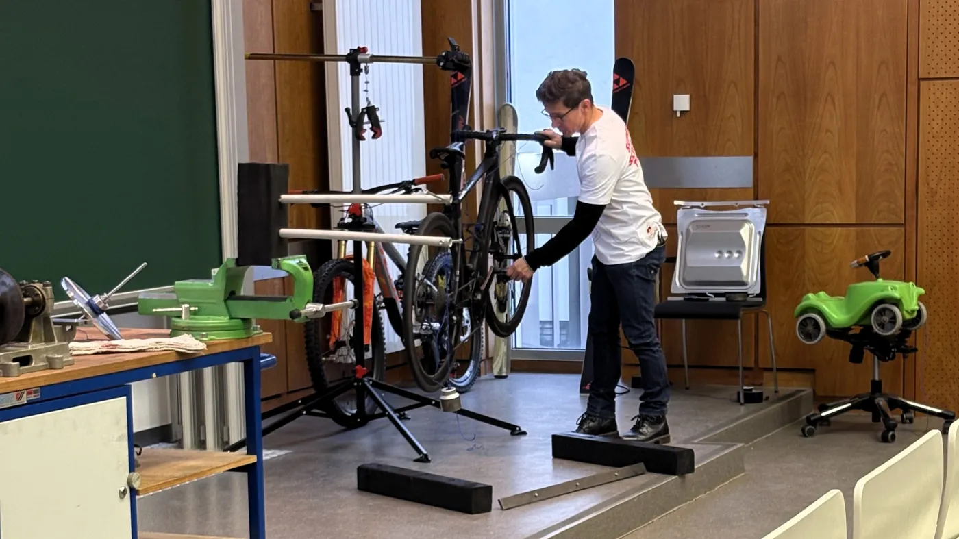 Beim Experiment: Ein Vortragender demonstriert die Fahreigenschaften an einem aufgeh&auml;ngten Mountainbike.
