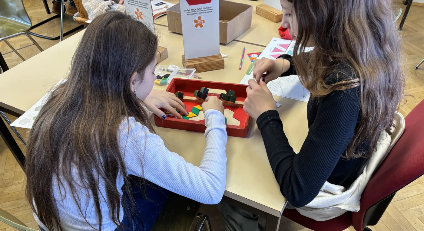 Zwei M&auml;dchen arbeiten gemeinsam an einem Geometrie-Puzzle
