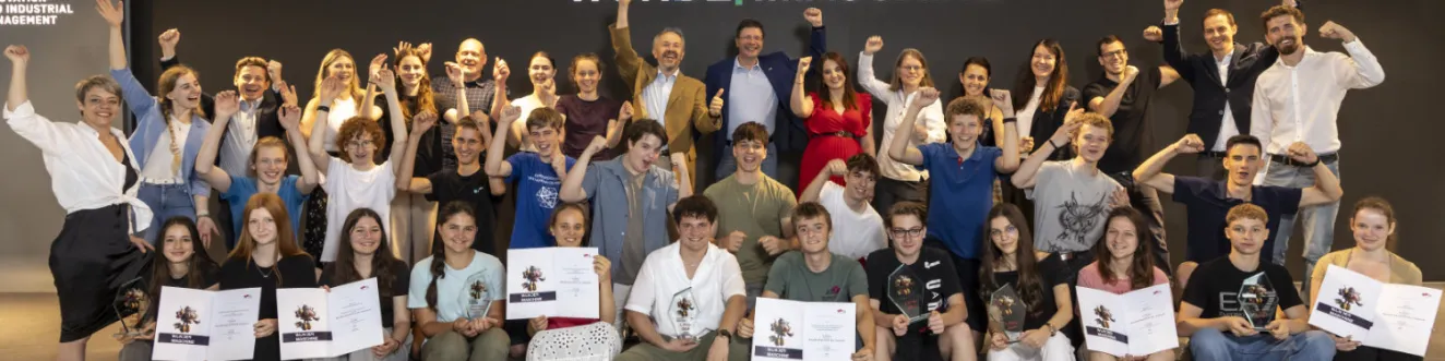 Die Jubelnden Gewinner*innen des Wettbewerbs "Wundermaschine" der TU Graz pr&auml;sentieren stolz ihre Urkunden und Pokale.
